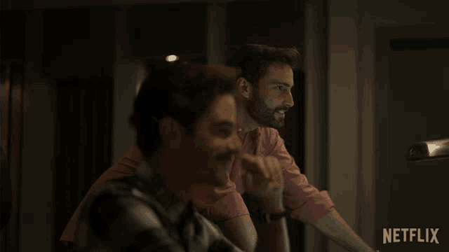 two men are waving their hands in front of a netflix sign