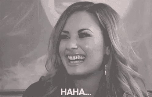 a black and white photo of a woman laughing with the words `` haha '' written on the bottom .