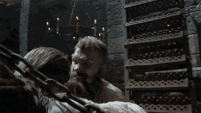 a man with a beard is chained to another man 's back