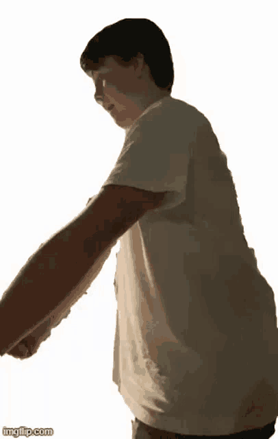 a young man is standing with his arms outstretched in front of a white background .