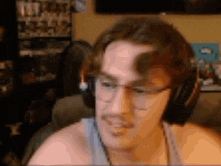 a man wearing headphones and glasses is sitting on a couch in a room .