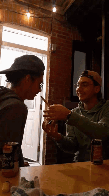 two men are sitting at a table with a can of sierra mist beer
