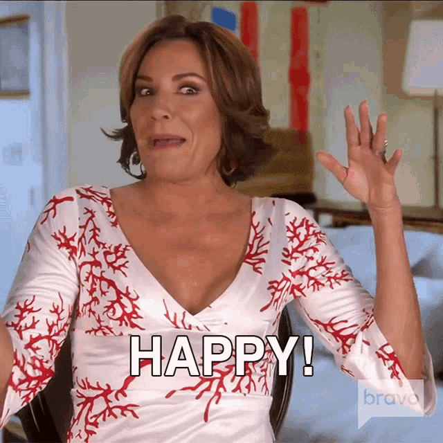 a woman wearing a white and red dress says happy