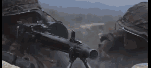 a close up of a soldier holding a gun with a blurred background