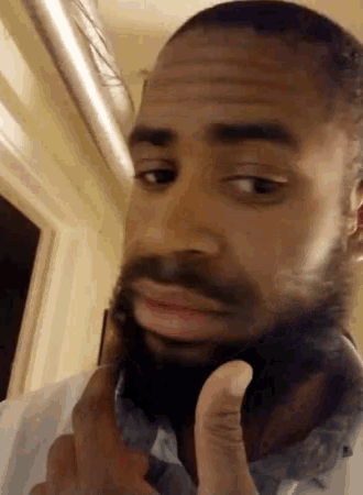 a man with a beard is making a funny face with his hand