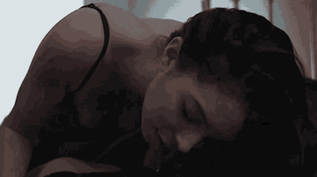 a woman in a black bra is laying on the floor with her head down