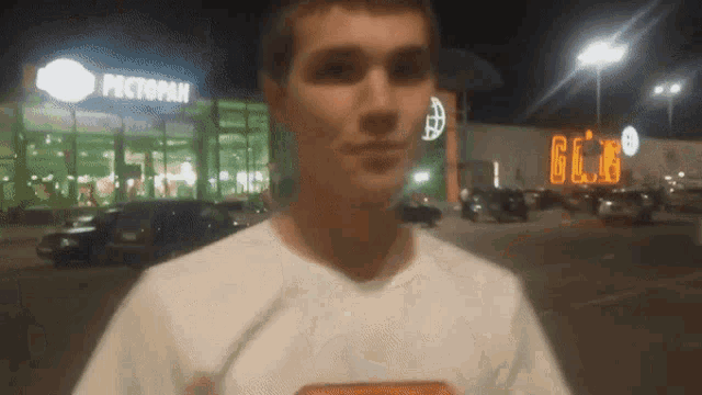 a man in a white shirt stands in front of a restaurant that says pectopan