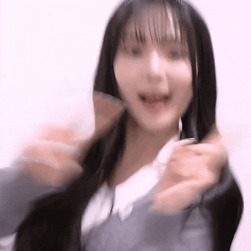 a young woman with long black hair is making a funny face while wearing a headband .