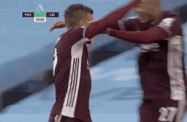 two soccer players are hugging each other during a game .