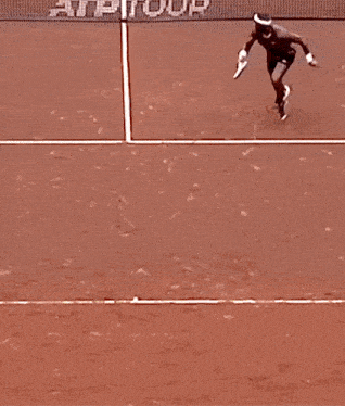 a person laying on a tennis court with the word atp on it