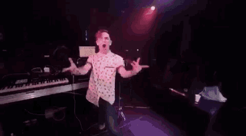 a man is dancing on a stage in front of a crowd in a club .
