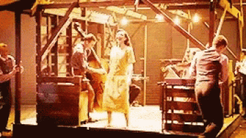 a group of people are standing on a stage playing instruments