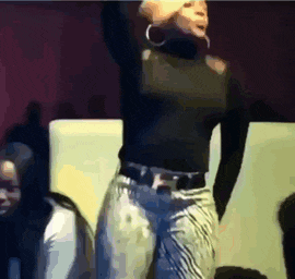 a woman in a black top and jeans is dancing