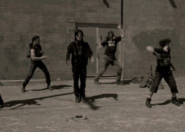 a group of men are standing in front of a brick wall