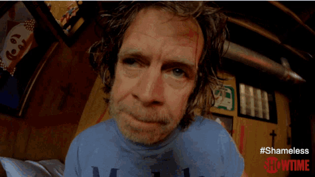 a man wearing a blue modelo shirt is making a surprised face
