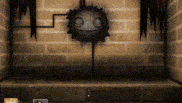 a dark room with a brick wall and a smiley face on the wall