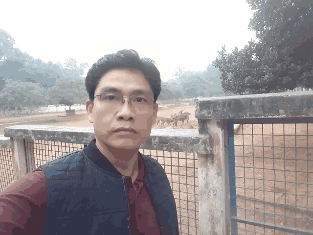 a man taking a selfie in front of a fence