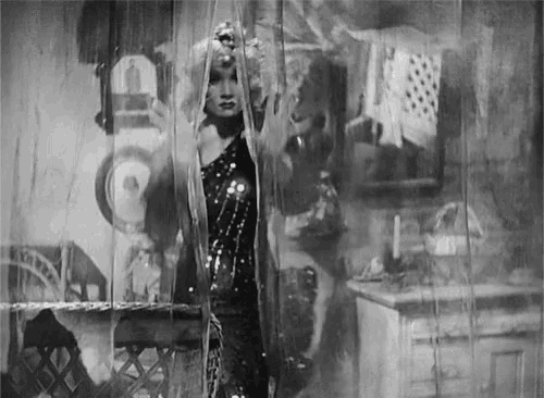 a black and white photo of a woman behind a curtain with the word otto on the wall