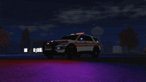 a white and orange state police vehicle is parked on the street at night