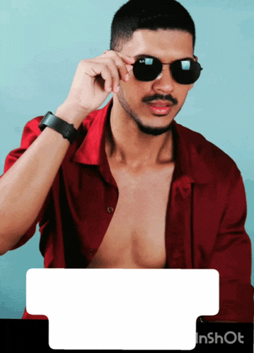 a man wearing sunglasses and a red shirt is standing in front of a blue background