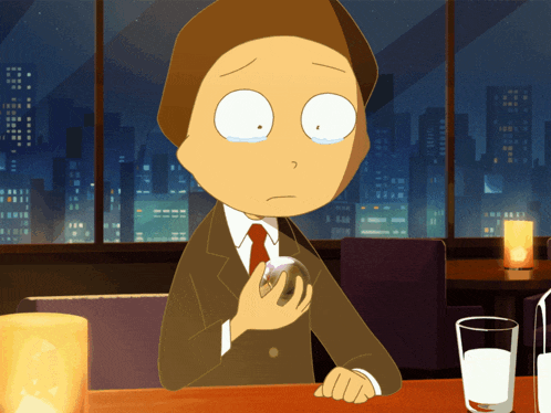 a man in a suit and tie is sitting at a table with a glass of milk
