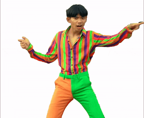 a young man in a colorful shirt and pants is pointing at something