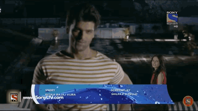 a man in a striped shirt stands in front of a screen that says sony on it