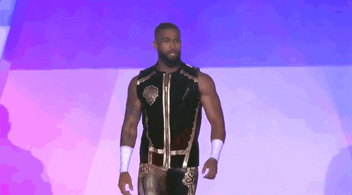a wrestler in a black vest with a gold emblem on it