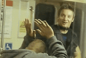 a man sitting on a train with his hands up and a handicap sign behind him