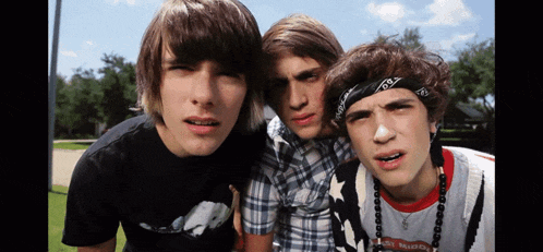 three boys are posing for a picture and one of them has a bandana on his head that says r.i.p