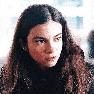 a close up of a woman 's face with long brown hair