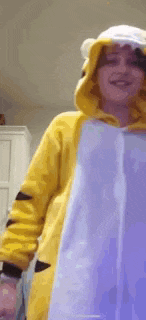 a person wearing a yellow and purple hoodie with a white hat on .