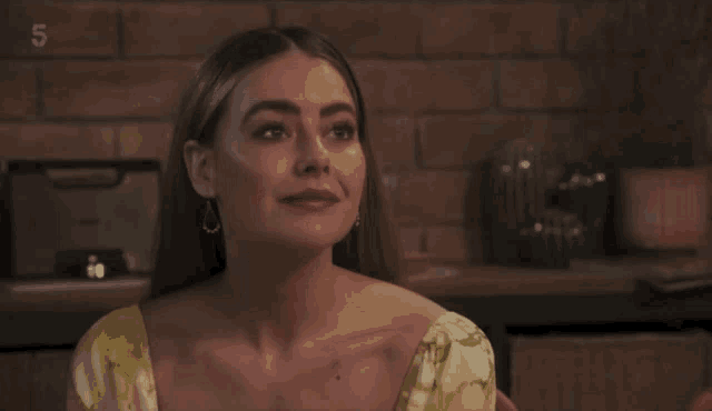 a woman in a yellow dress is smiling and the number 5 is on the bottom right