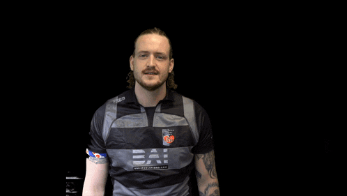 a man with a tattoo on his arm is wearing a shirt that says ' warriors ' on the front