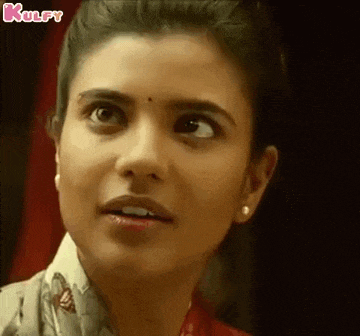 a close up of a woman 's face with a surprised expression on her face .