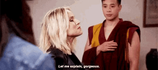 a woman is talking to a man in a robe while a man in a robe looks on .