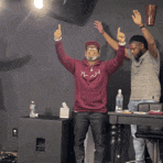 a man in a maroon hoodie is standing next to another man