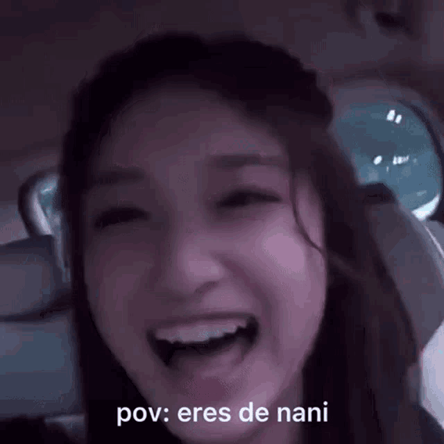a close up of a woman laughing in a car with the words pov : eres de nani written next to her .