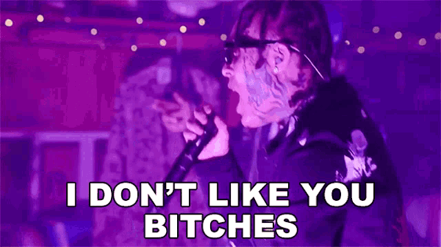 a man singing into a microphone with the words i do n't like you bitches