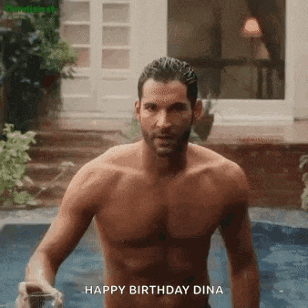 a shirtless man is standing in a pool holding a glass of wine .