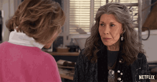 a woman with gray hair is talking to another woman in a netflix advertisement