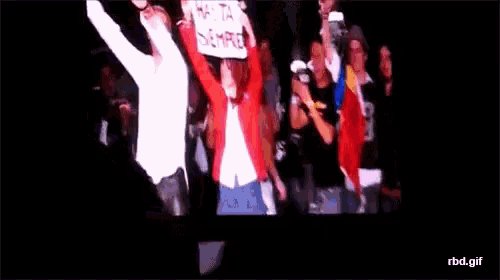 a woman holds up a sign that reads hasta siempre