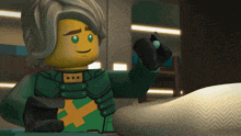 a lego figure is holding a green ball in his hand