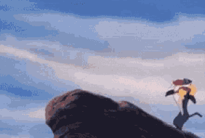 a person is standing on top of a large rock with a blue sky in the background