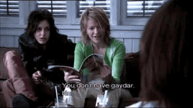 a group of women are sitting on a couch talking to each other .