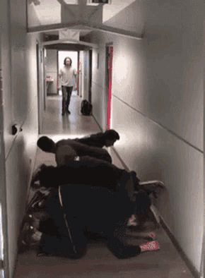 a group of people are laying on the floor in a hallway