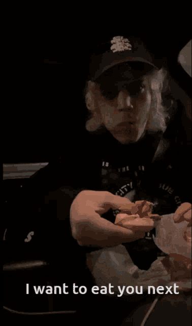a man wearing a hat and a shirt that says i want to eat you next