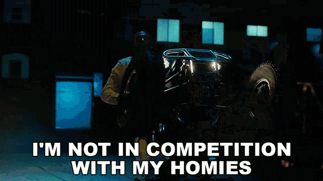 a man is holding a car with the words i 'm not in competition with my homies below him