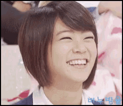 a woman with short hair is smiling with her eyes closed and a watermark that says ' a ' on it