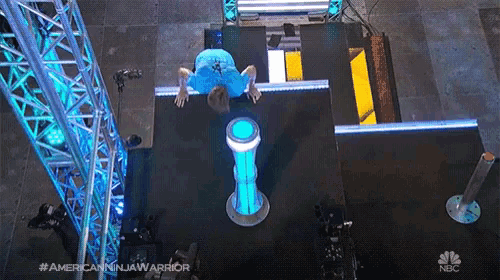 an aerial view of a person doing a handstand on a nbc television show called american ninja warrior